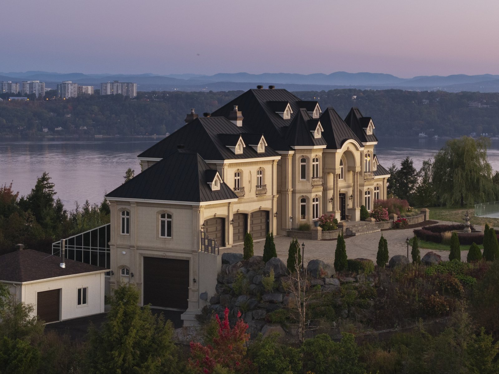 Manoir à tourelles surplombant le fleuve au lever du jour, vue drone