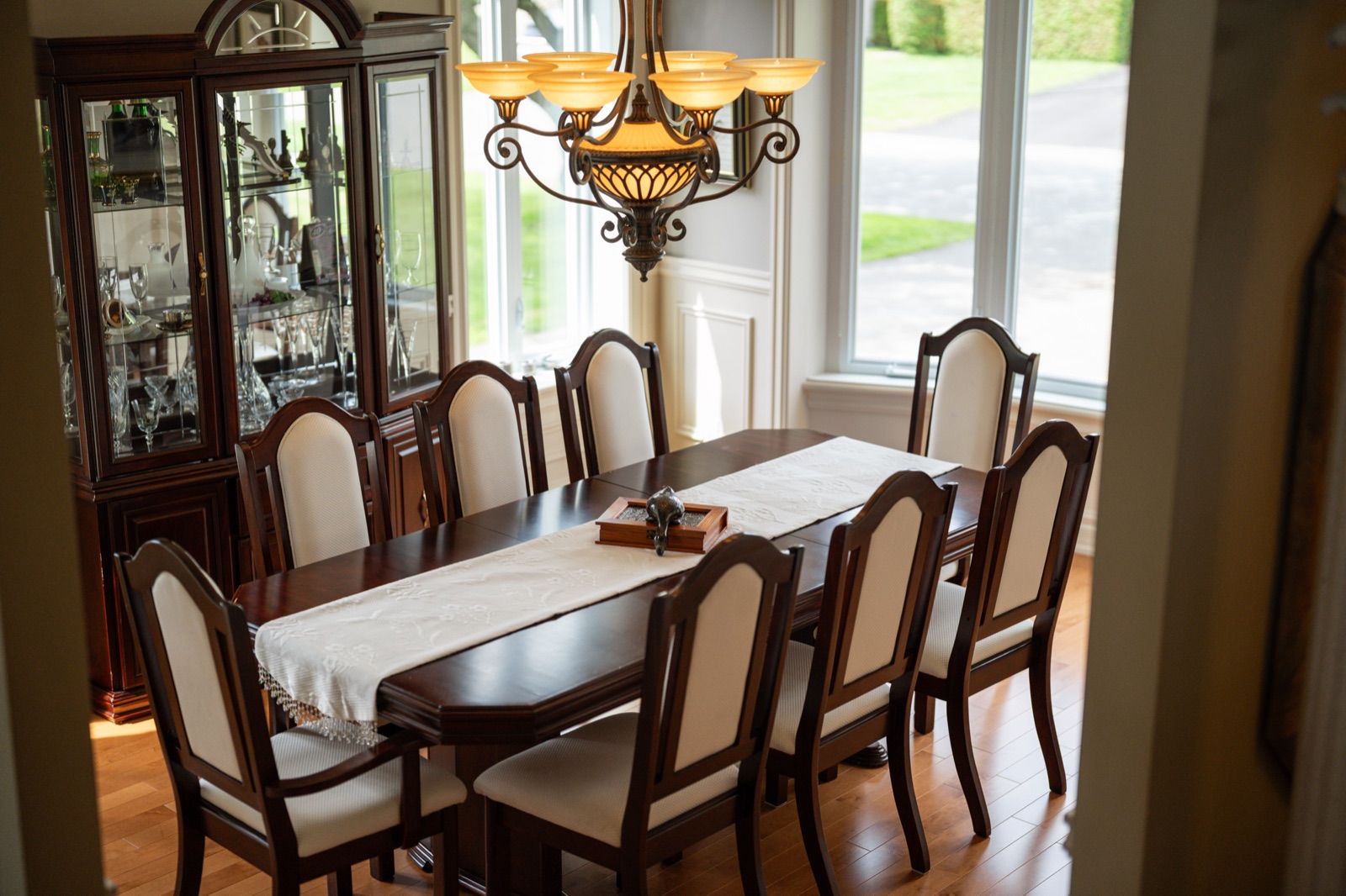 Salle à manger formelle, table de huit couverts sous le lustre à abat-jour ambrés