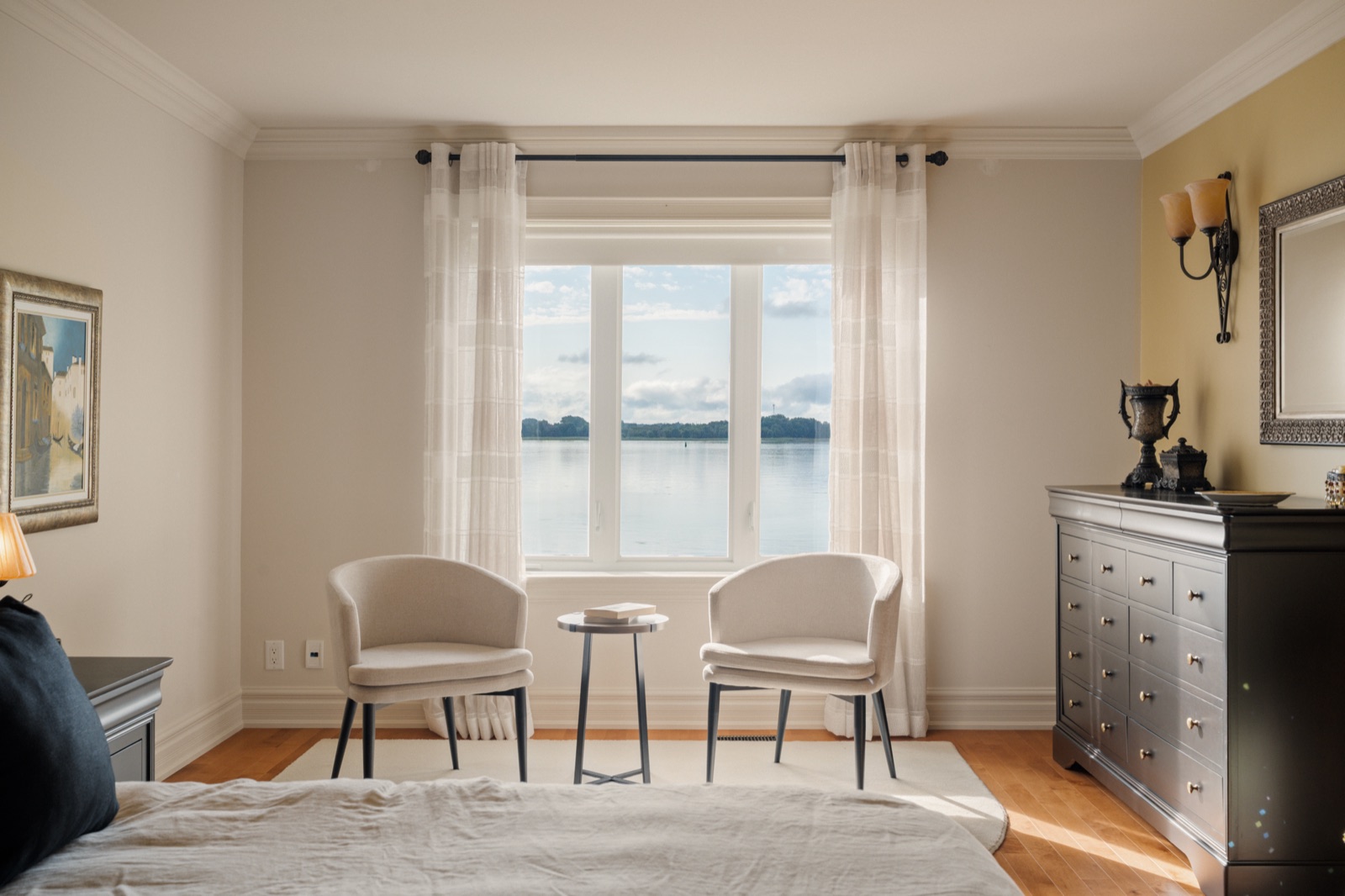 Chambre des maîtres avec coin lecture devant la fenêtre sur le fleuve