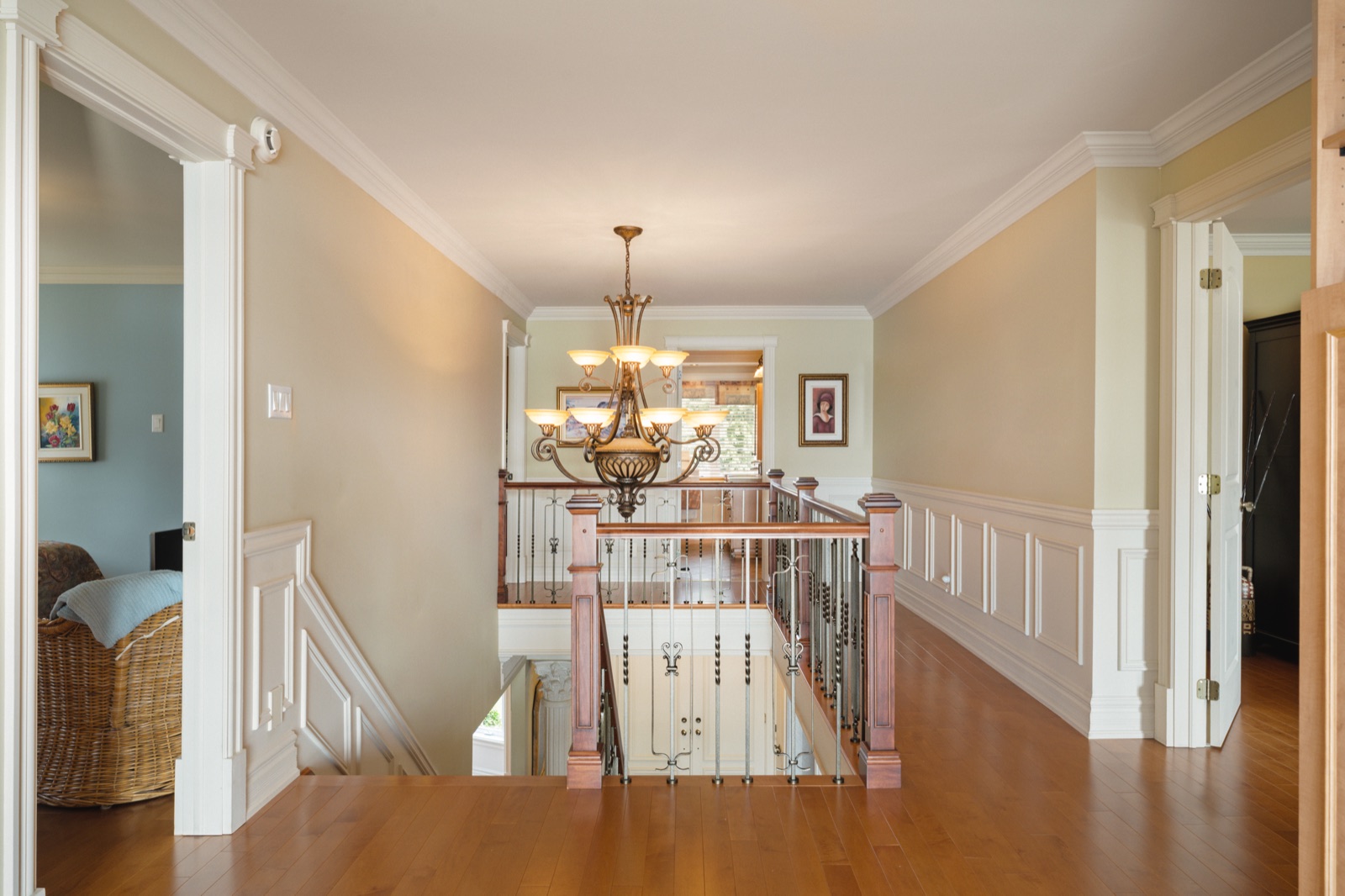Palier de l'étage avec balustrade et lustre au-dessus de l'escalier