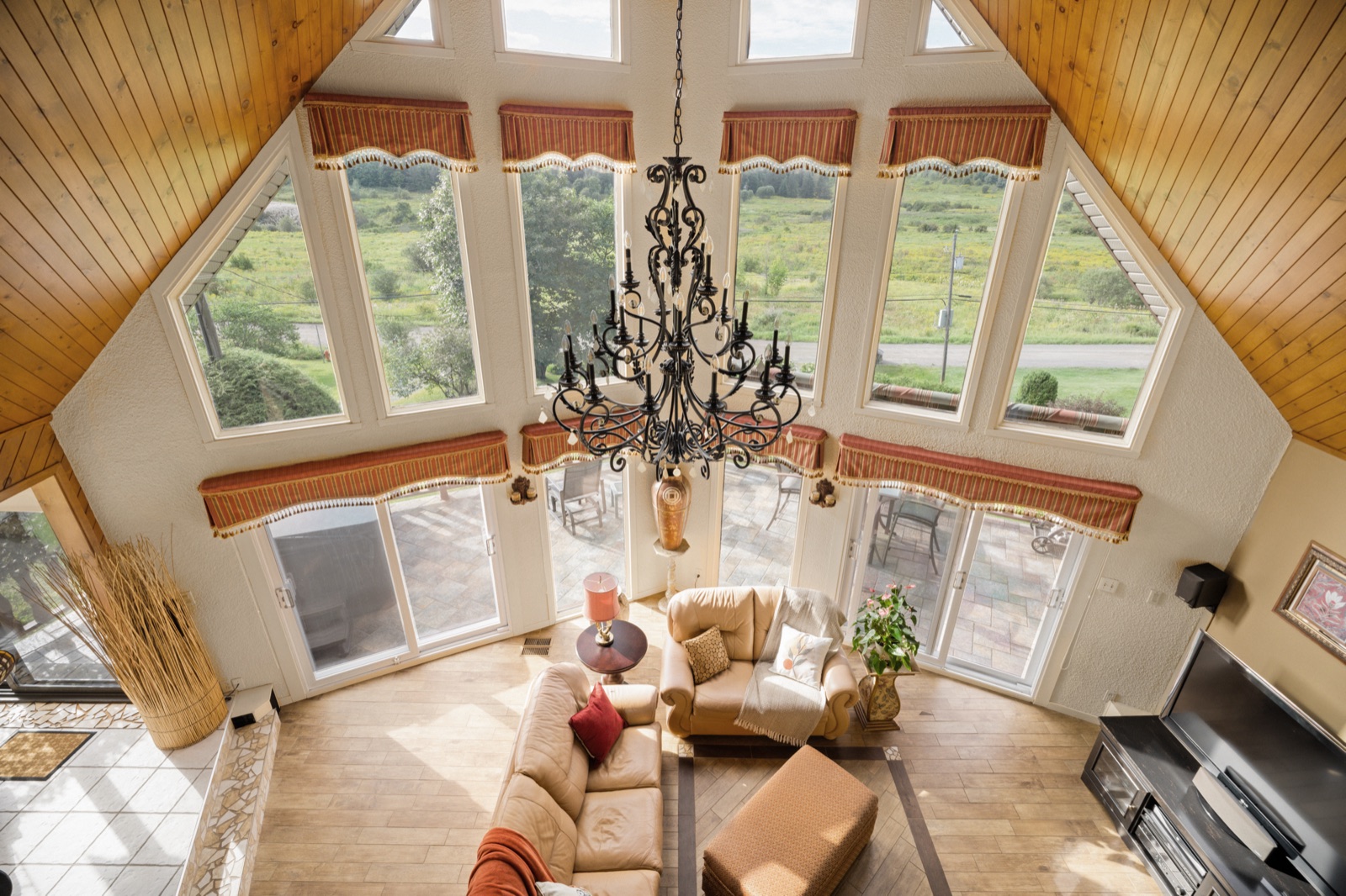 Vue de la mezzanine sur le séjour, chandelier de fer et rangée de fenêtres en pointe